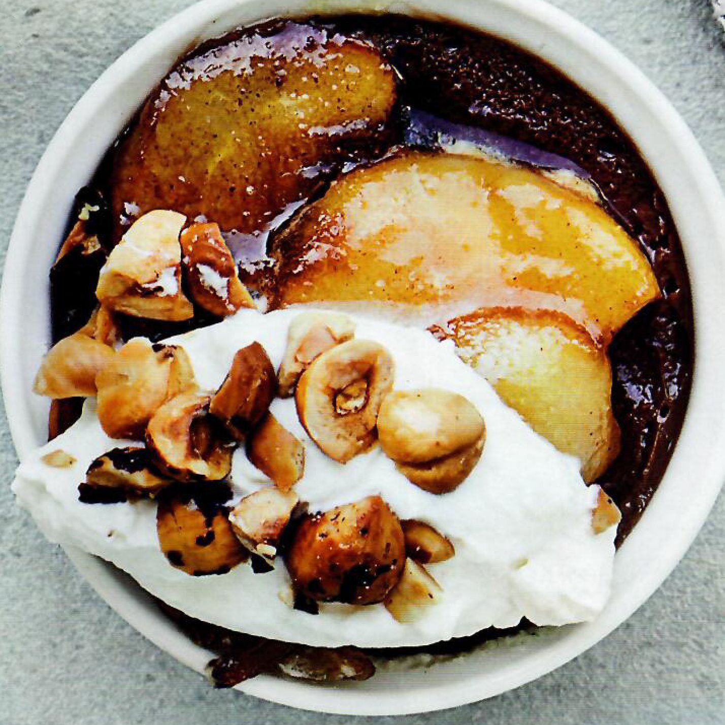 A bowl of food with whipped cream and nuts on top