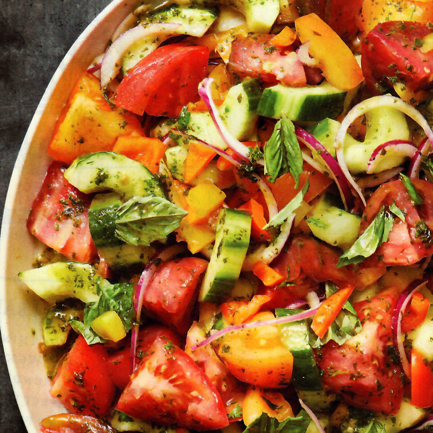A close up of a salad with tomatoes and cucumbers