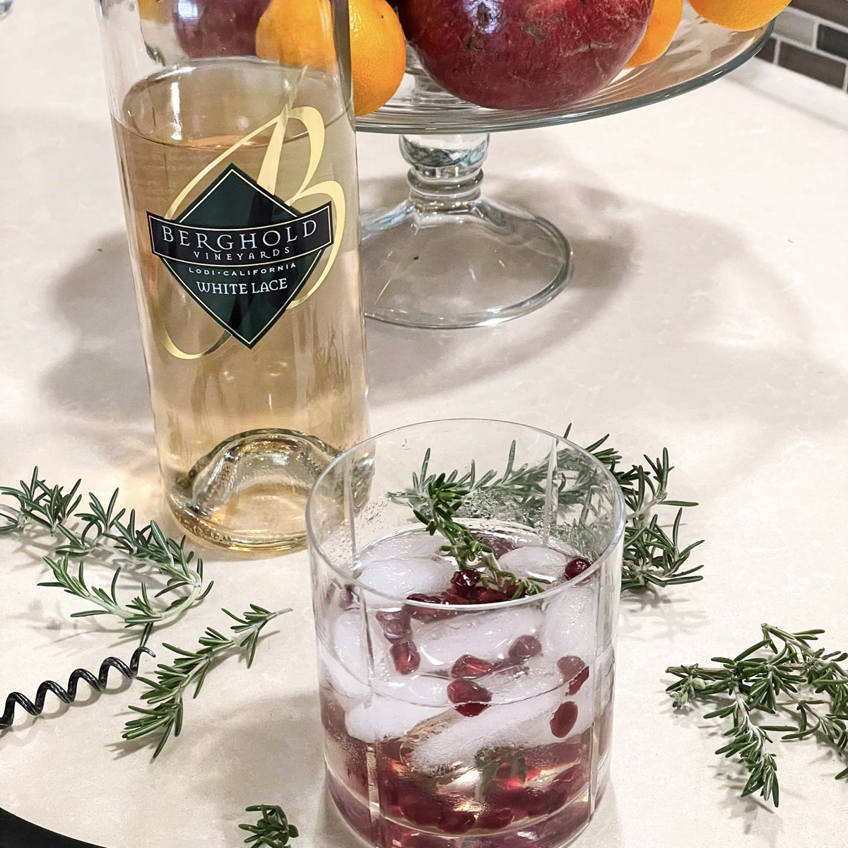 A bottle of wine sits on a table next to a glass of wine