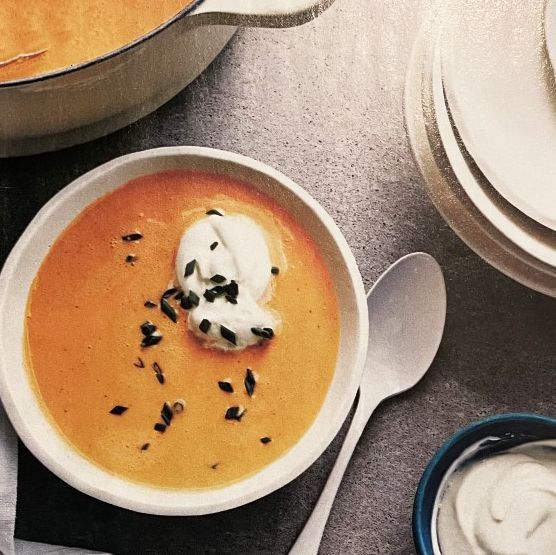 A bowl of soup with whipped cream on top