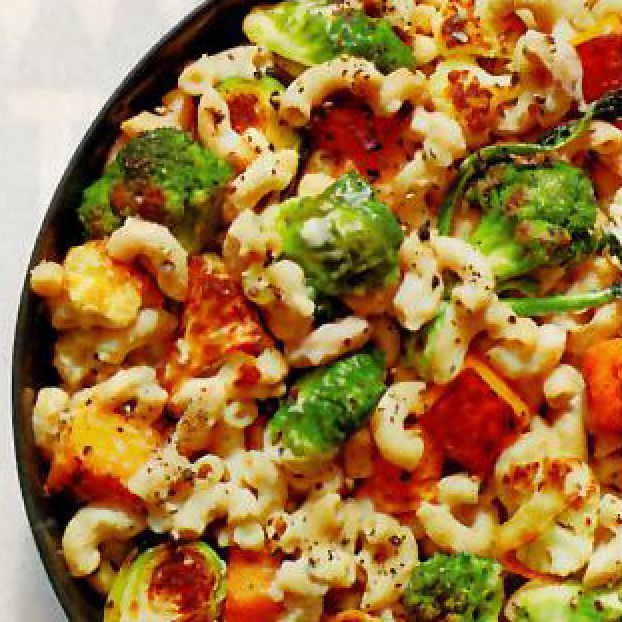 A close up of a pasta salad with broccoli and carrots
