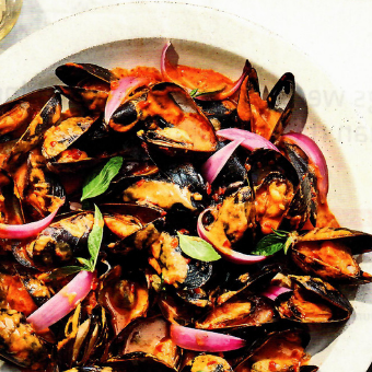 A close up of a plate of food with mussels and onions