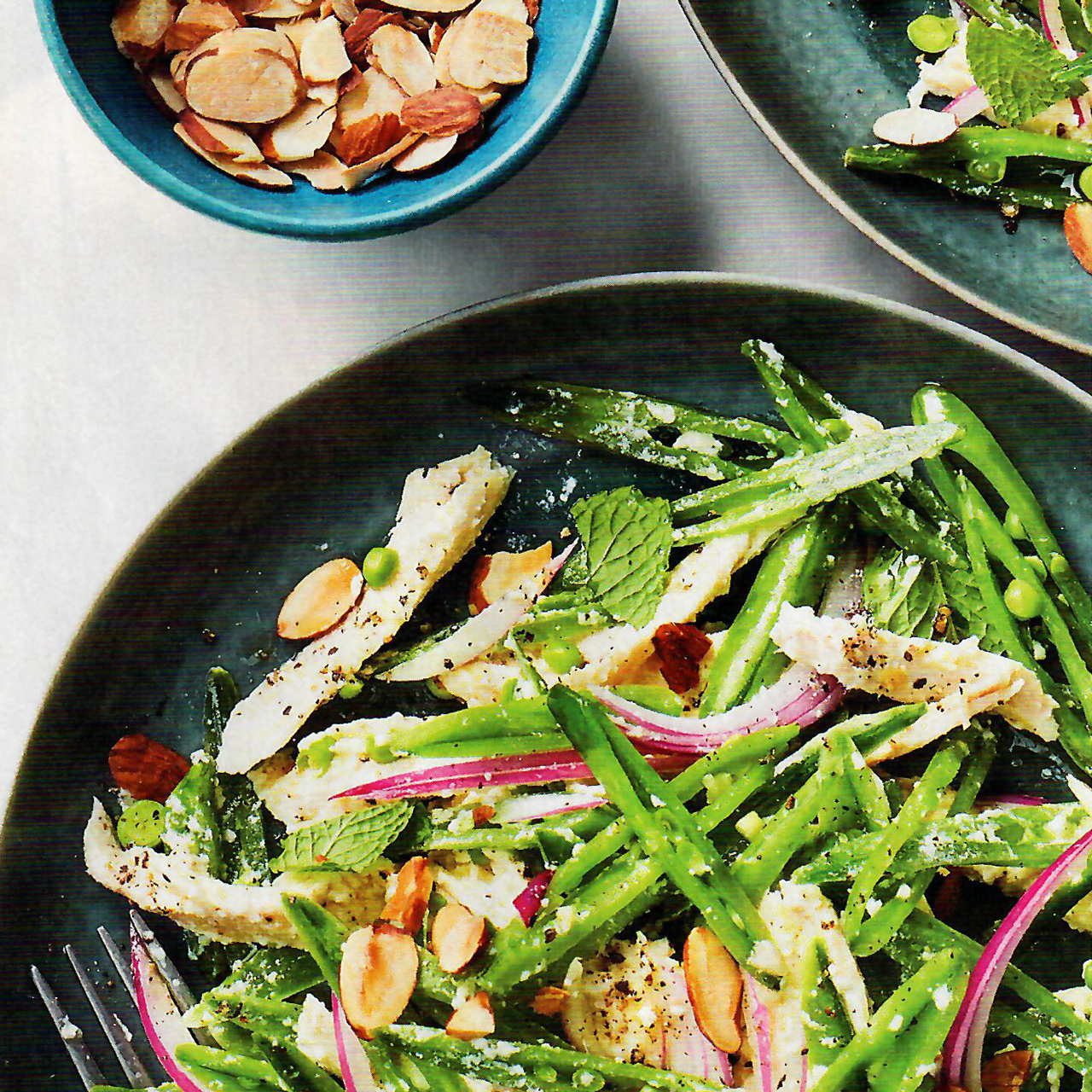 A salad with green beans onions and almonds on a plate