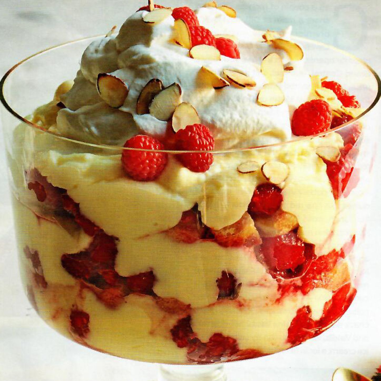 A glass bowl filled with strawberries and whipped cream