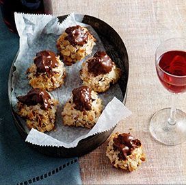 A bowl of chocolate covered cookies next to a glass of wine