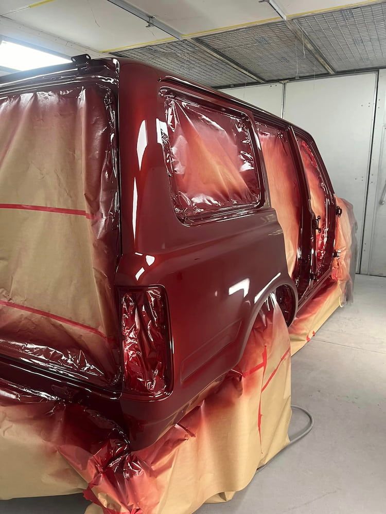A Red Van Is Being Painted In A Paint Booth — ABS Repairs in Manunda, QLD