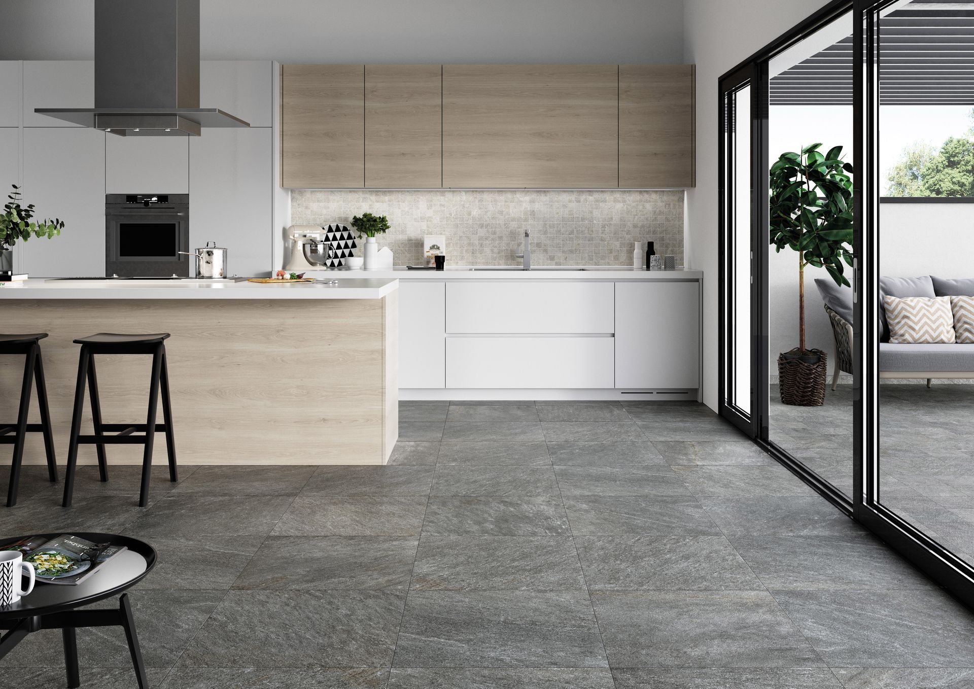 Moderne Küche mit hellen Holzschränken, weißen Arbeitsplatten und grauem Fliesenboden. Große Glastüren führen auf eine Terrasse.
