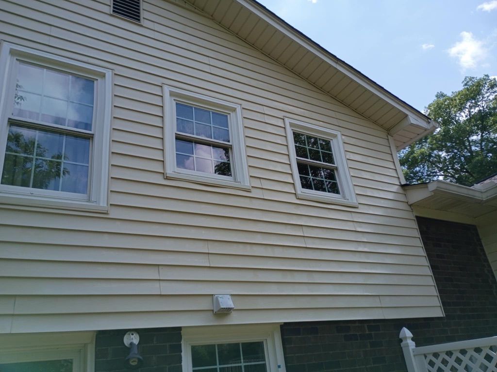 Side of a beige house with three windows and white trim, Pressure Washing & Window Cleaning in Huntsville