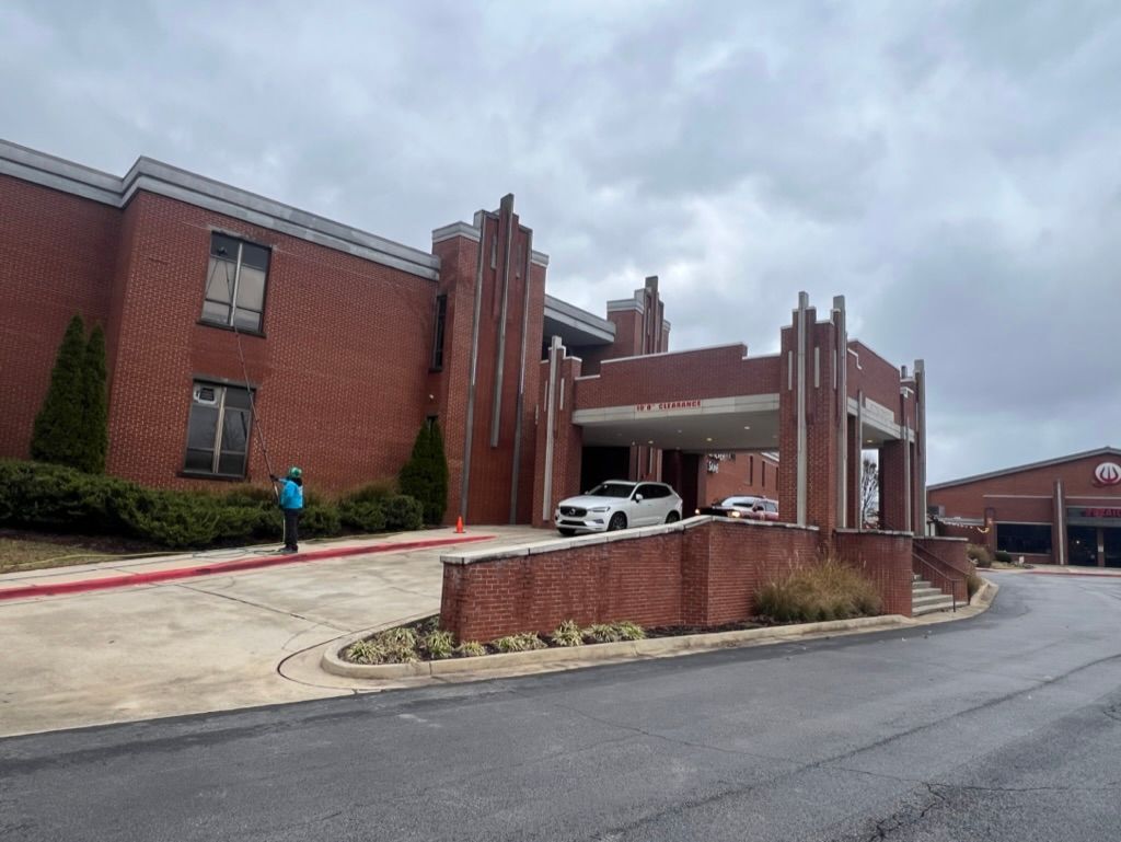 Brick building entrance with white car, covered drop-off area,. Pressure Washing & Window Cleaning in Huntsville