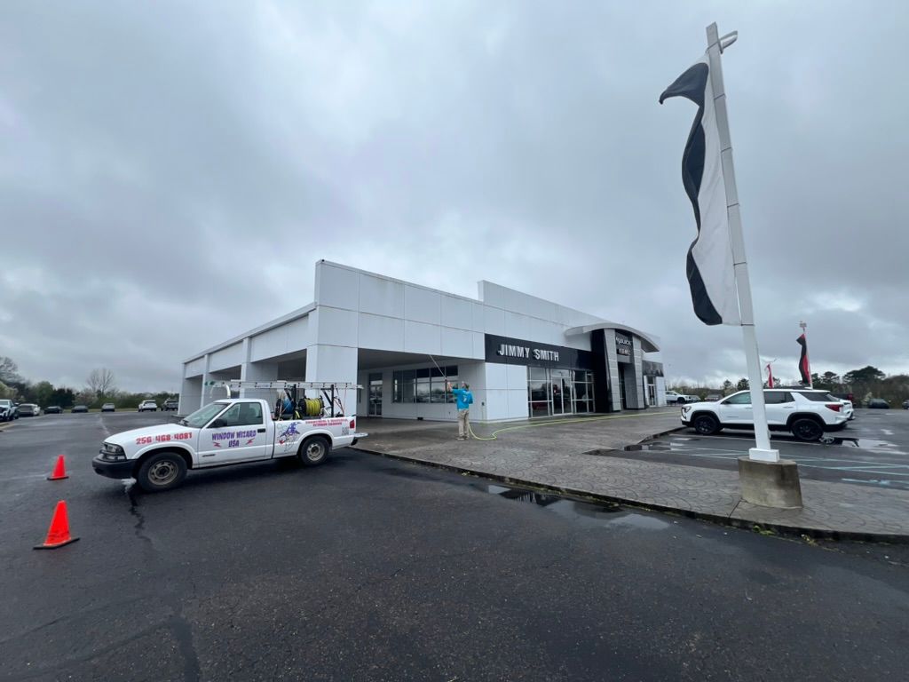 Car dealership lot with white building, parked cars, Pressure Washing & Window Cleaning in Huntsville
