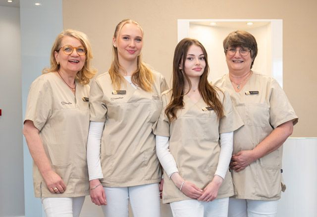 Das Team von ZahnFlair Eine Gruppe von Frauen in OP-Kleidung posiert für ein Foto.