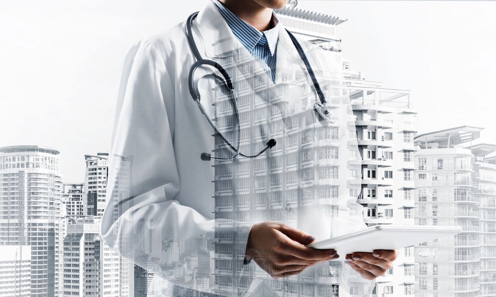 Un médico con un estetoscopio alrededor del cuello sostiene una tableta.