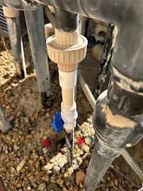 A close up of a pipe with a blue valve attached to it.