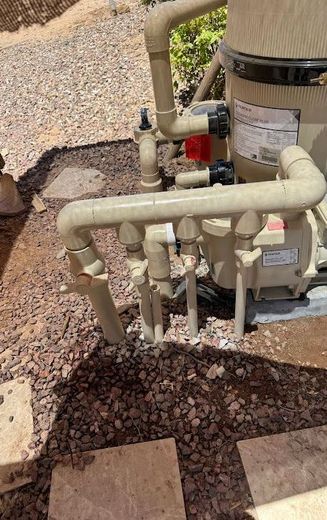 A swimming pool filter is sitting on top of a pile of gravel.