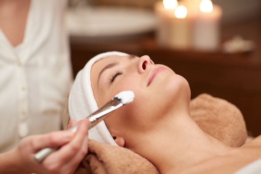 A woman is getting a facial treatment at a spa