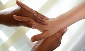 A person is giving a hand massage to another person.