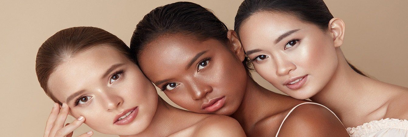 Three women of different races are posing for a picture together.