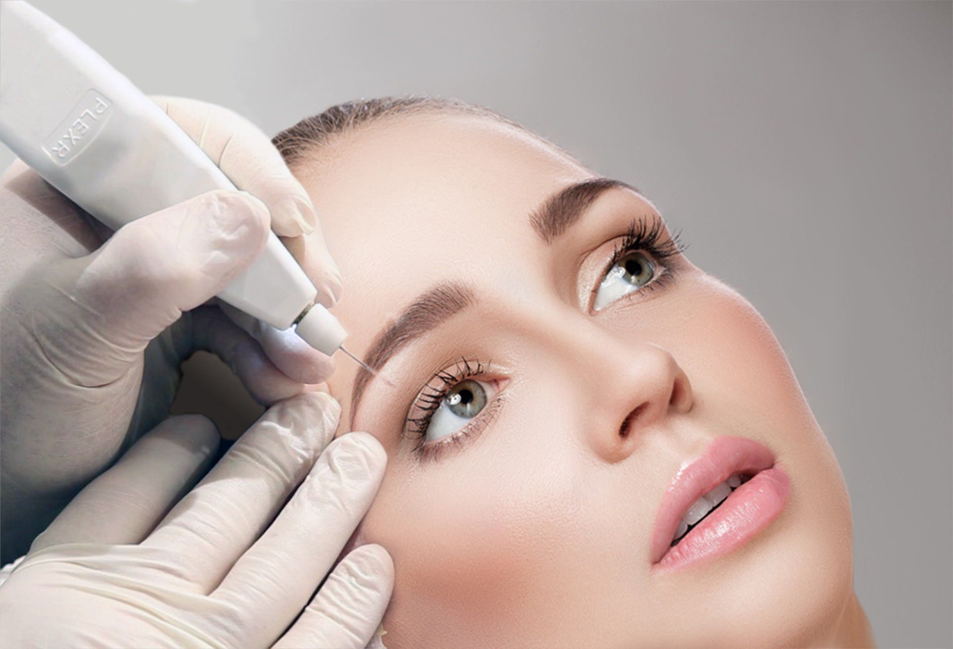 A woman is getting a tattoo on her eyebrows.