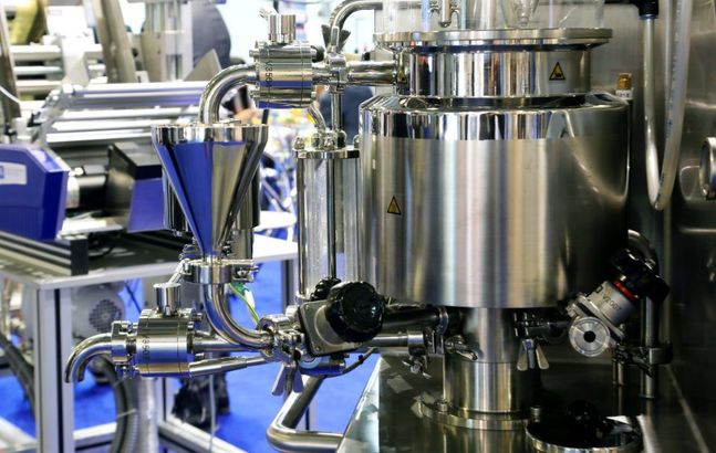 Macchinari industriali in acciaio inossidabile con tubi e serbatoi.