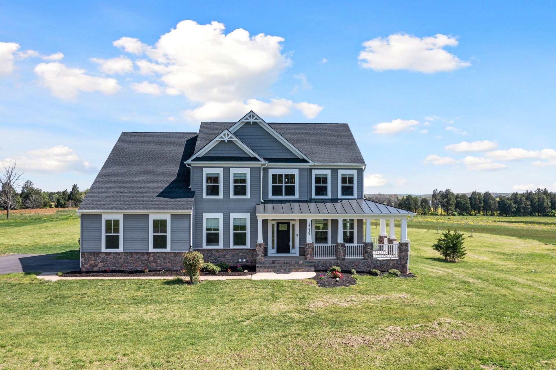 A large house is sitting on top of a lush green field. A large house is sitting on top of a lush green field.