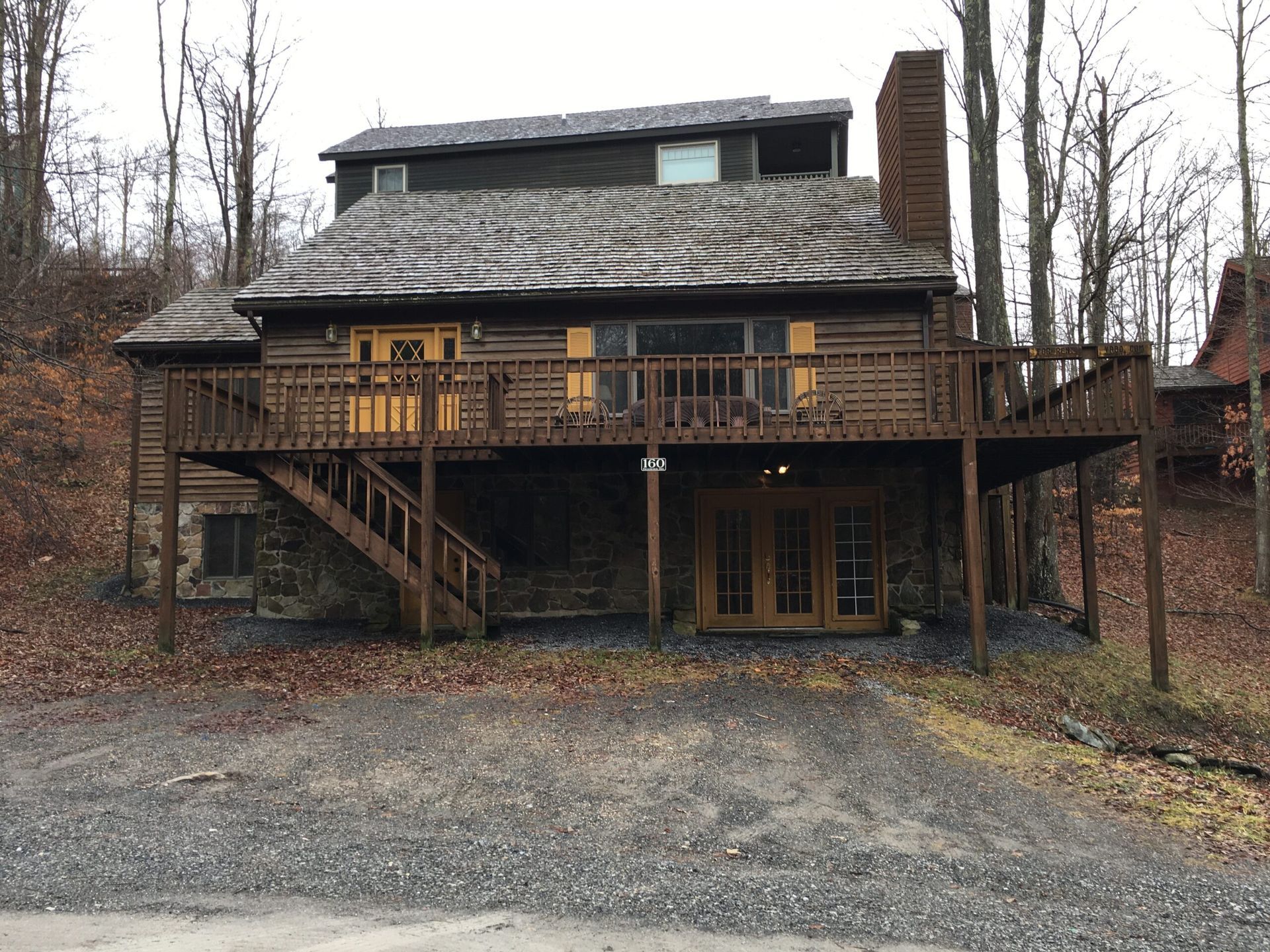 A large log cabin with a large deck and stairs A large log cabin with a large deck and stairs