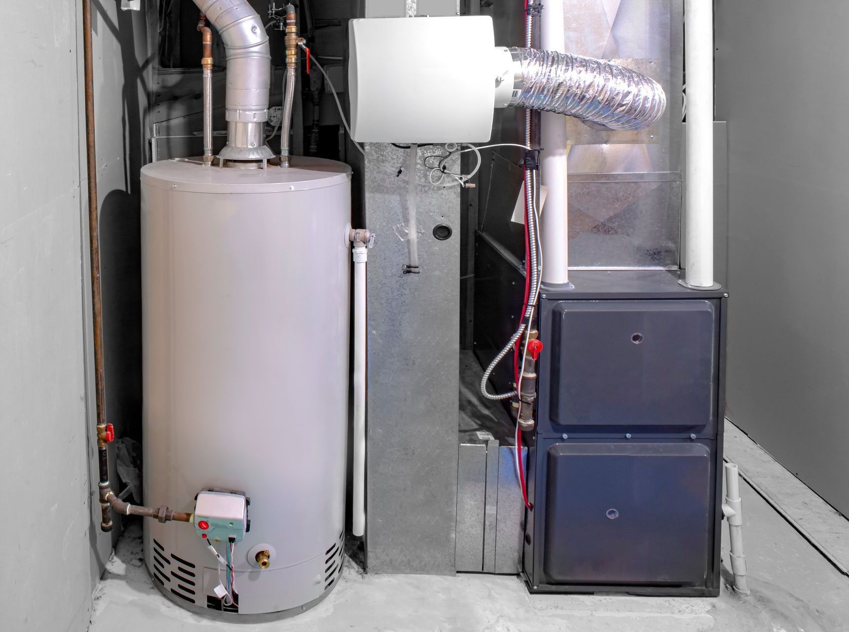 Water heater, furnace, and ductwork in a utility room, against gray walls.