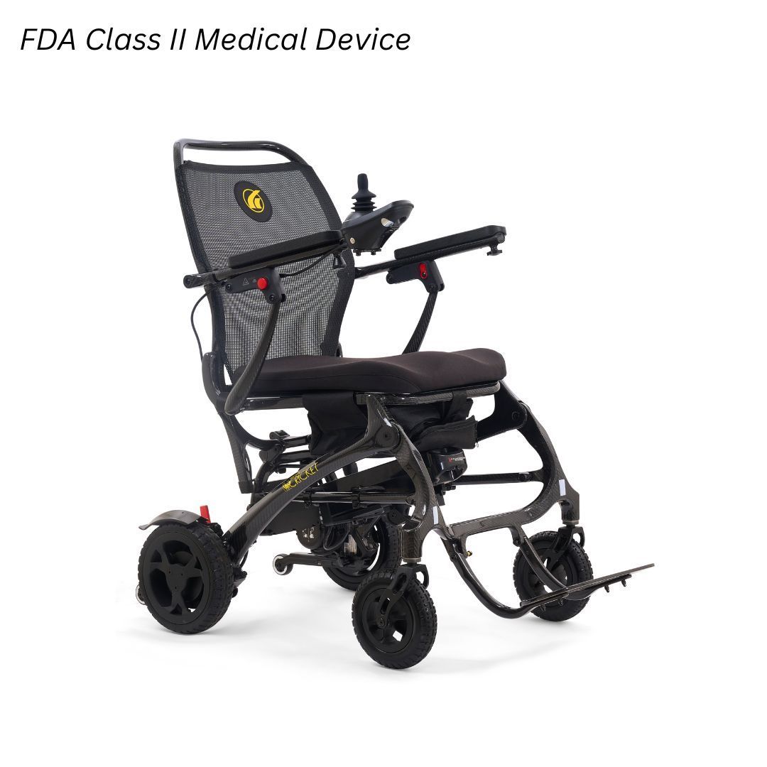 A foldable, dark gray power wheelchair with a mesh backrest and joystick controller, labeled an FDA Class II device.