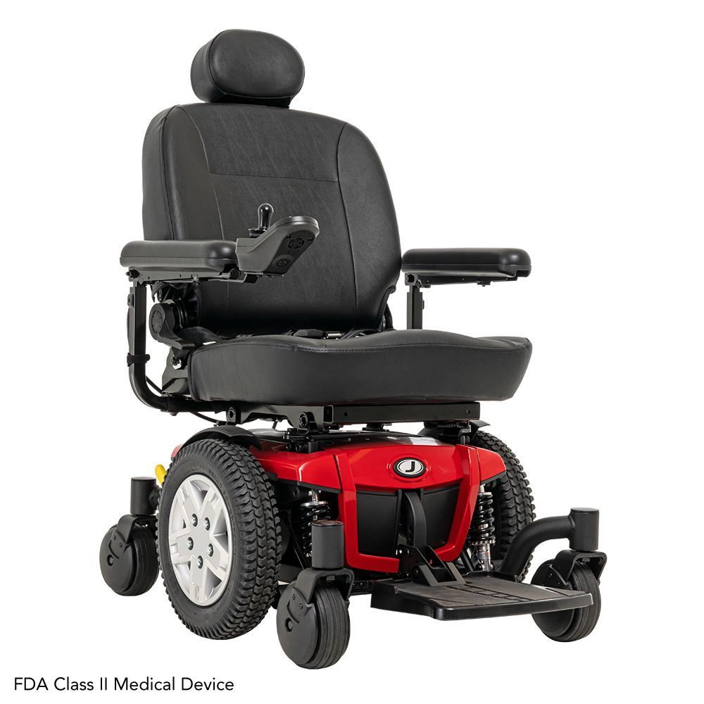 A red, four-wheeled power wheelchair with a black padded seat, headrest, and joystick control on a white background.