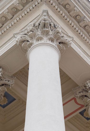 White column with ornate classical capital inside a grand building interior