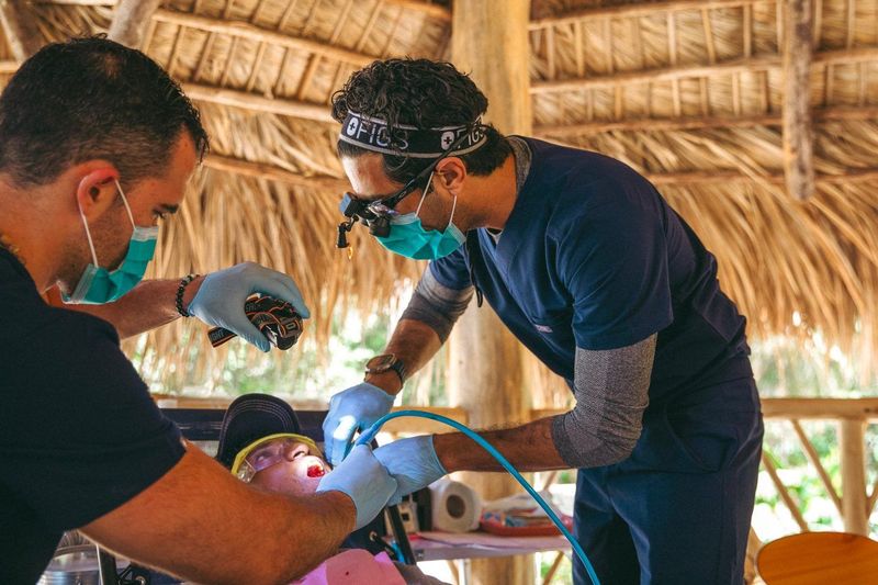 El Dr. Gaj y voluntarios brindando atención dental durante un viaje de ayuda