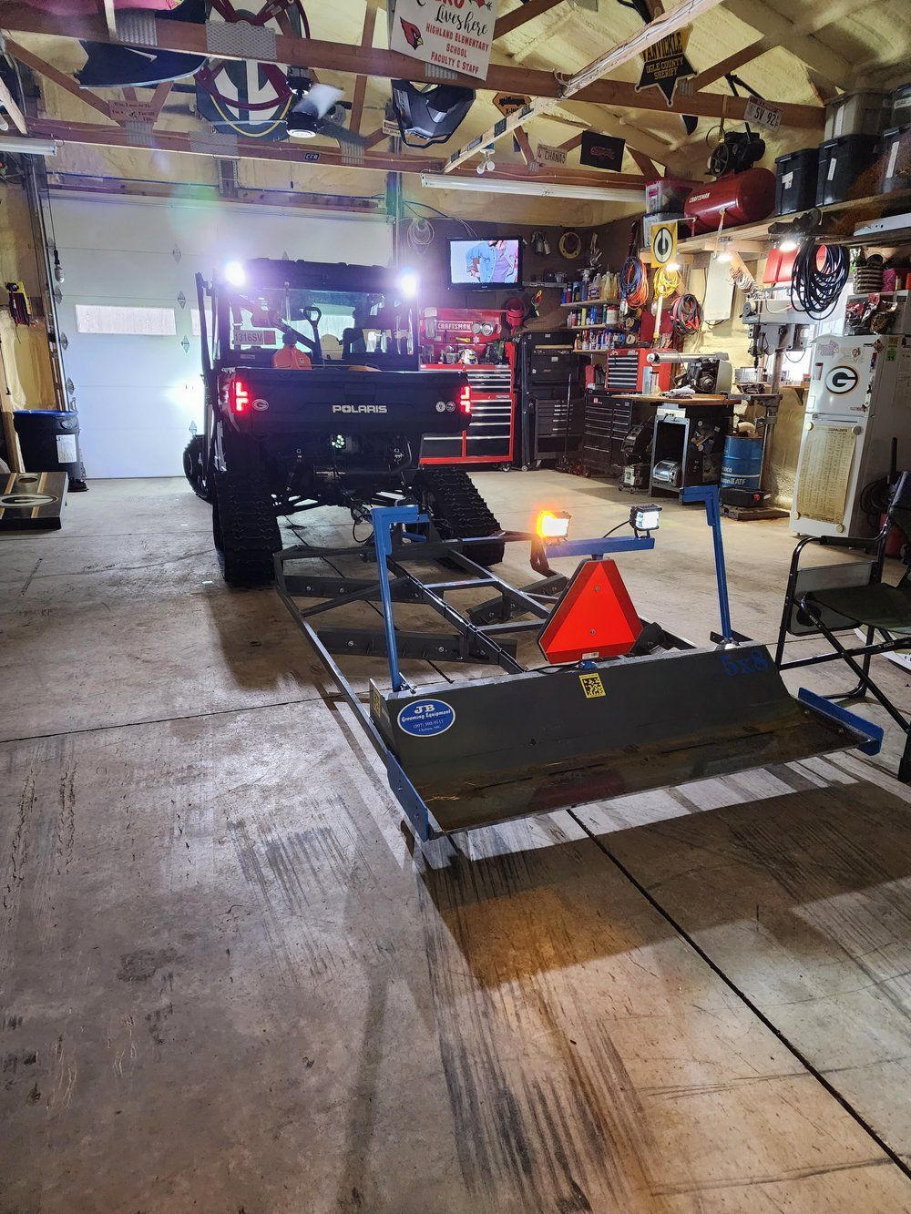 A vehicle is parked in a garage with a trailer attached to it.