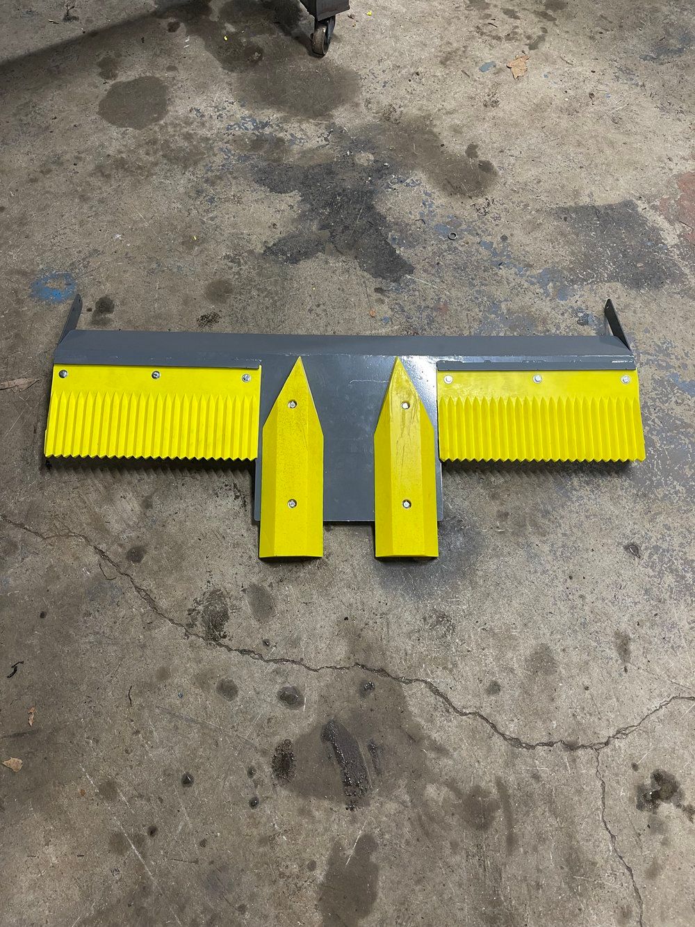 A yellow and gray object is sitting on a concrete floor.