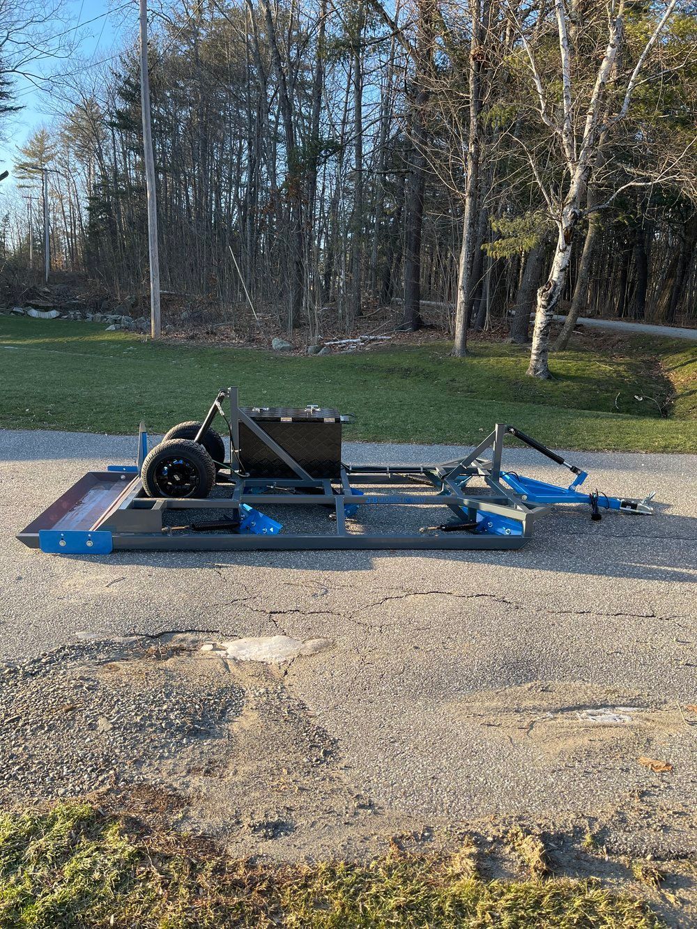 A motorcycle trailer is parked on the side of the road.
