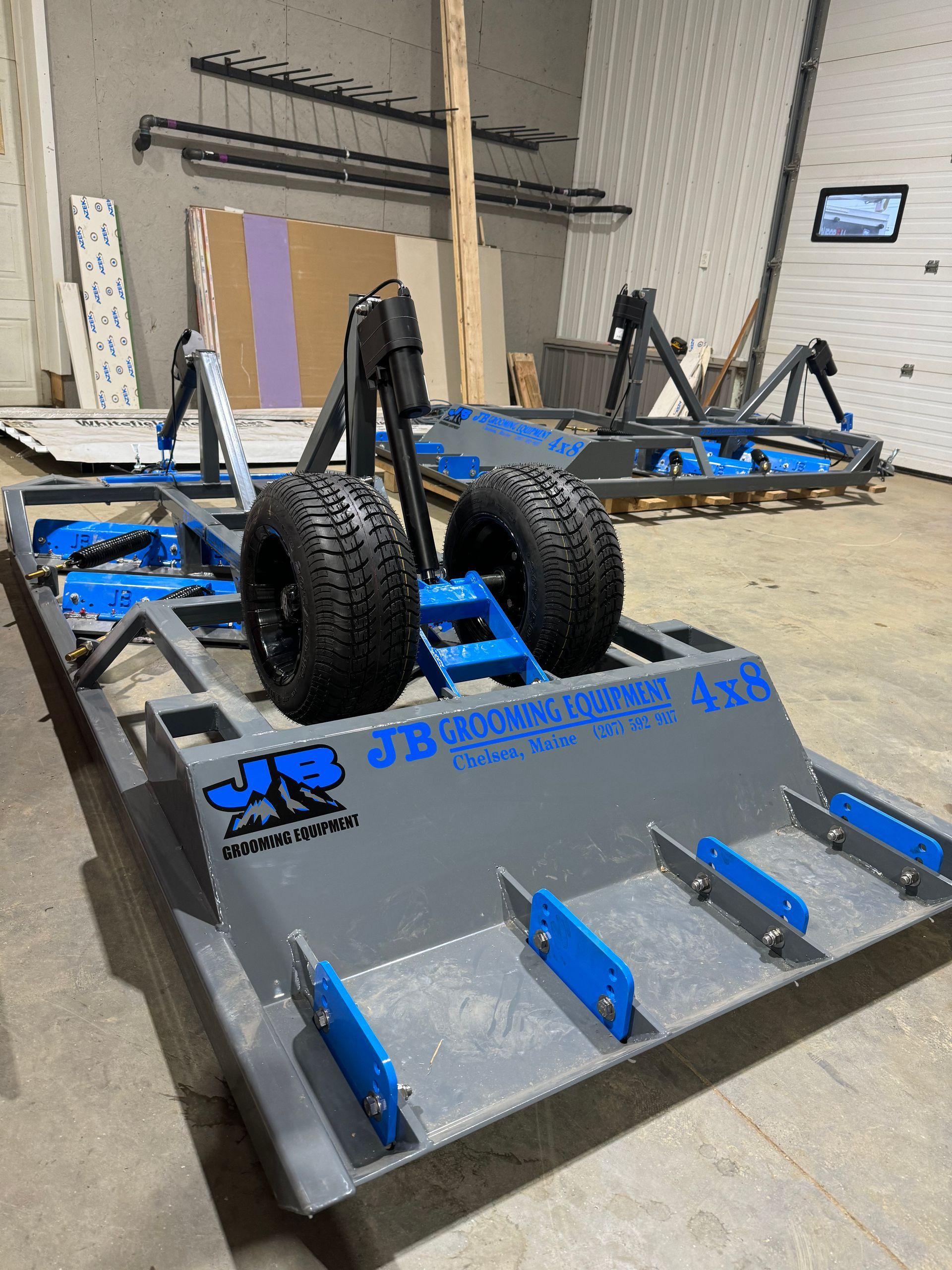 A blue and gray machine with wheels is sitting in a warehouse.