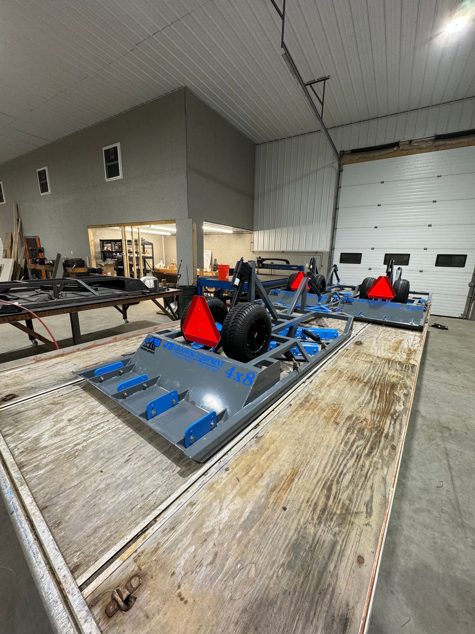 A bunch of vehicles are sitting on top of a wooden table in a garage.