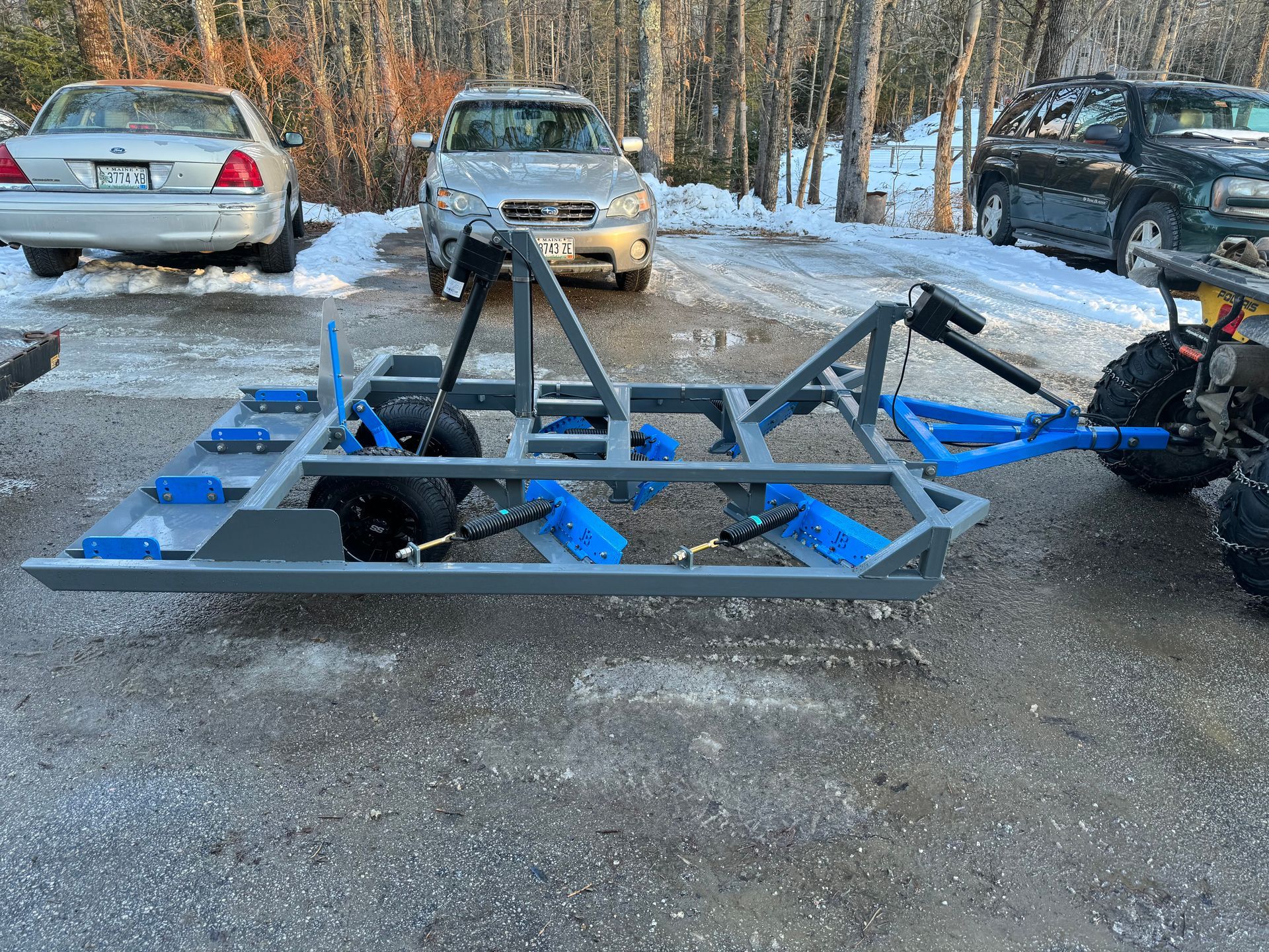 A car is parked next to a trailer in a parking lot.