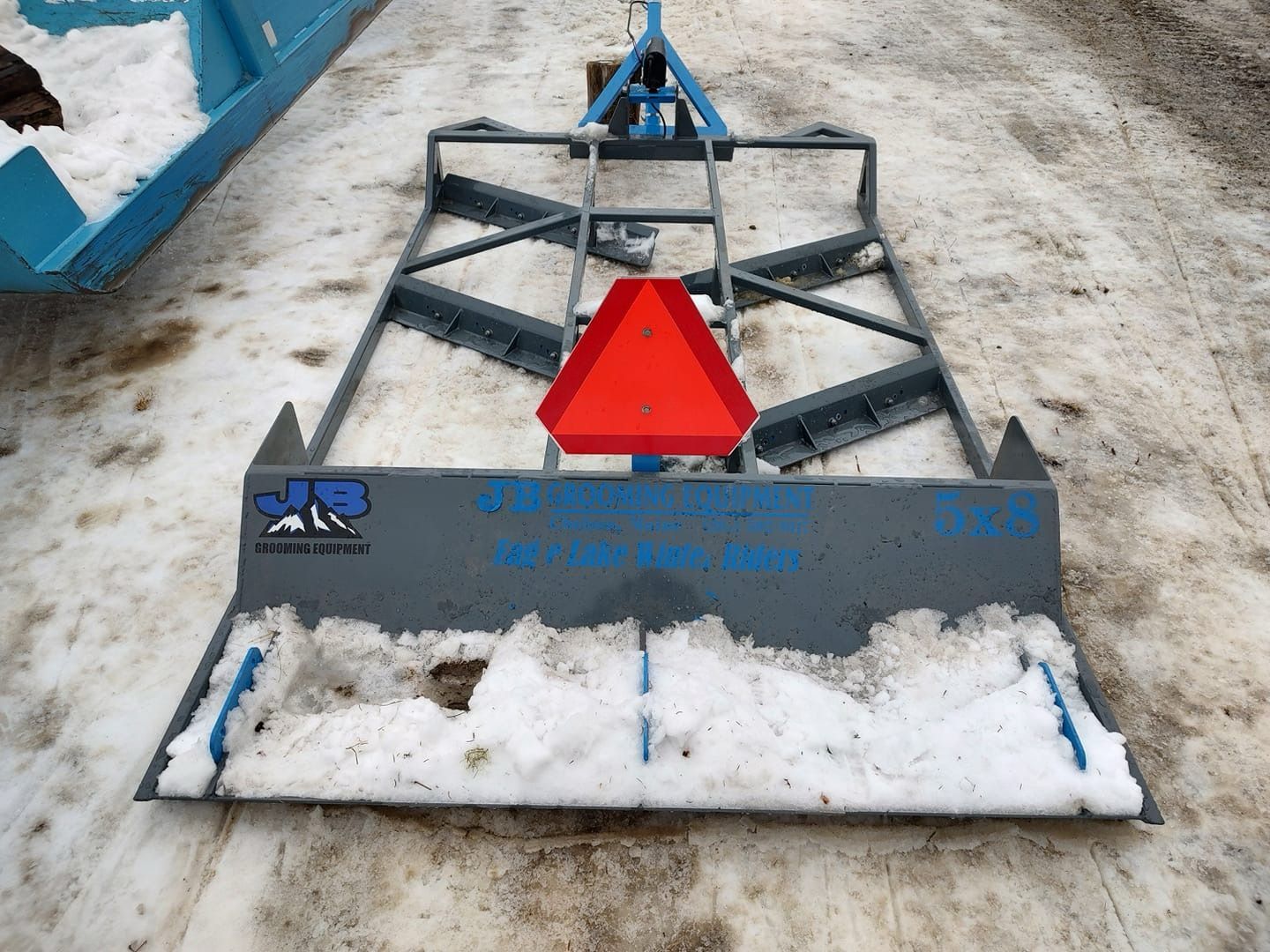 A snow plow with a red triangle on top of it