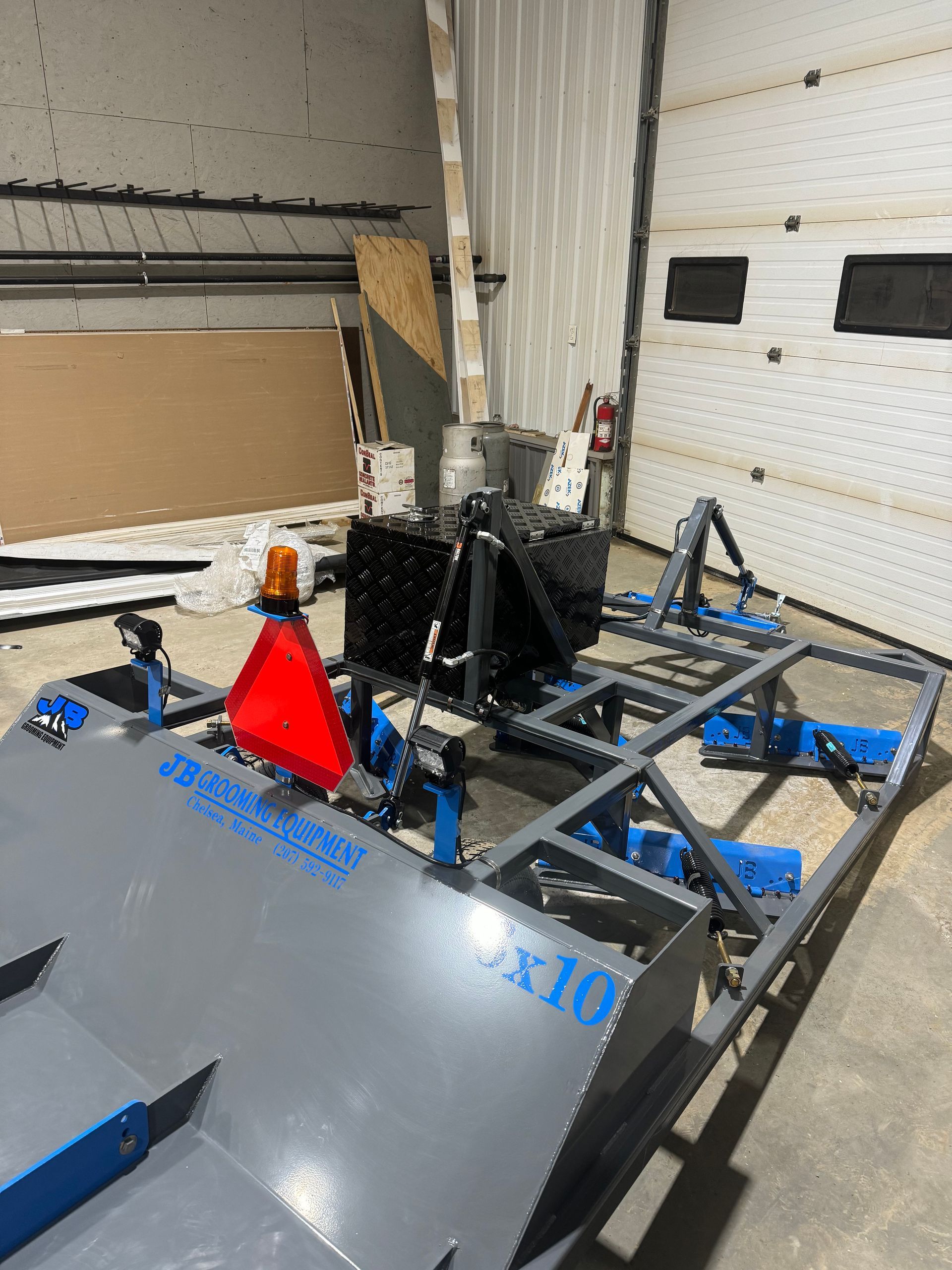A machine is sitting in a garage next to a garage door.