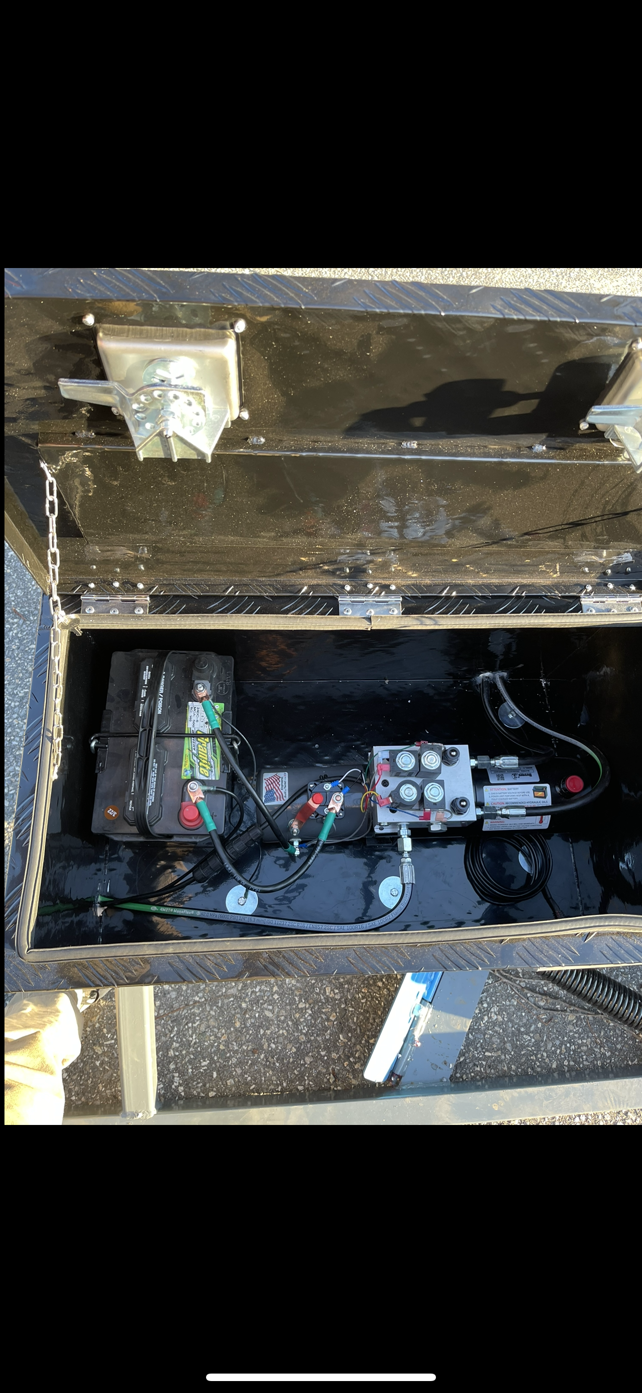 A hydraulic pump is sitting inside of a metal box.