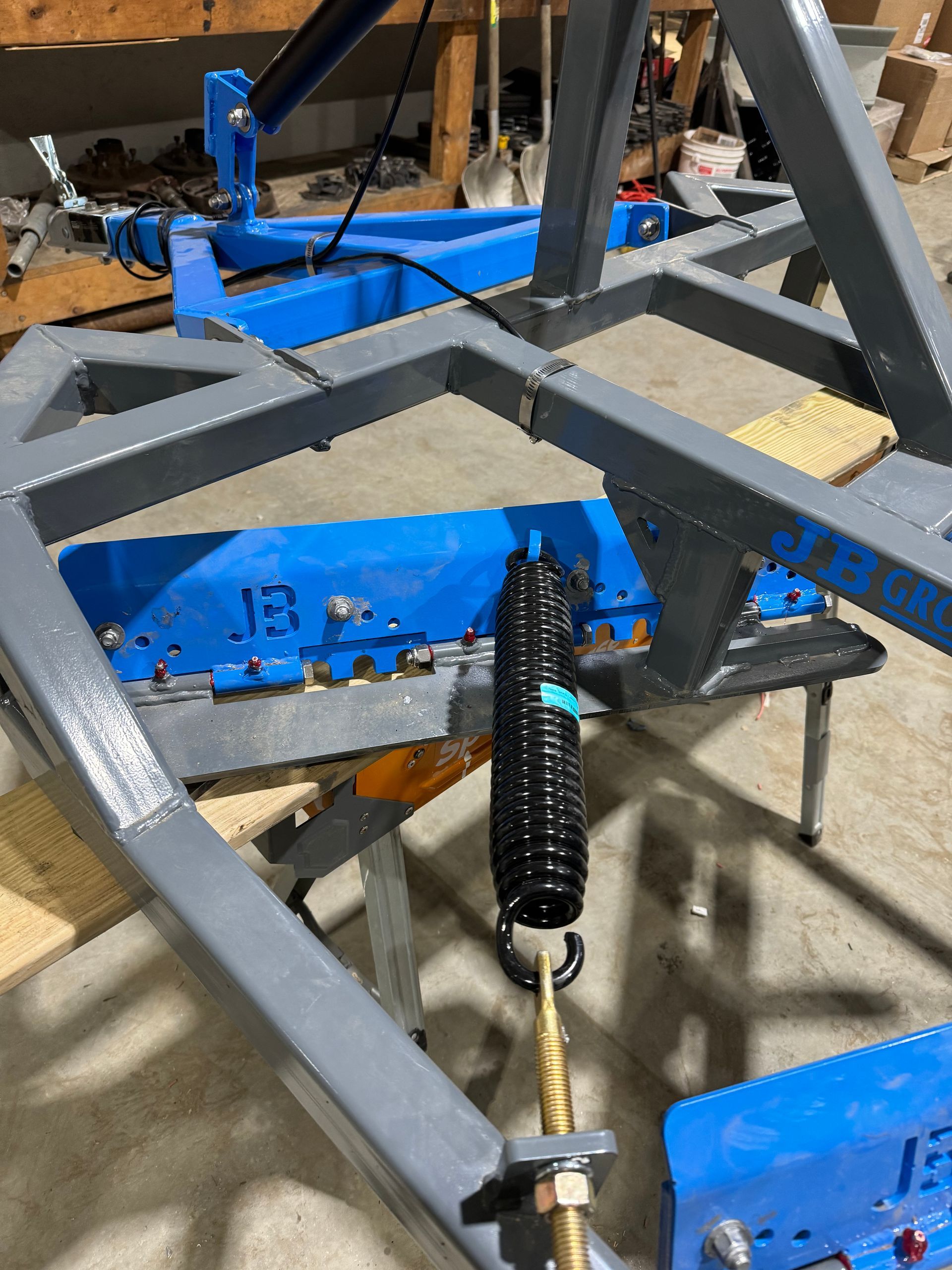 A blue and gray metal frame with a spring attached to it.