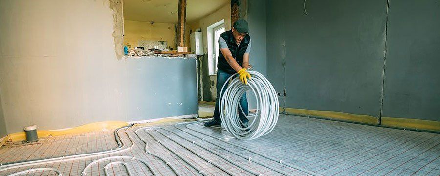 Man Installing Pipe Channel For Connecting Air Conditioner — Georgetown, TX — Roger Stuth AC