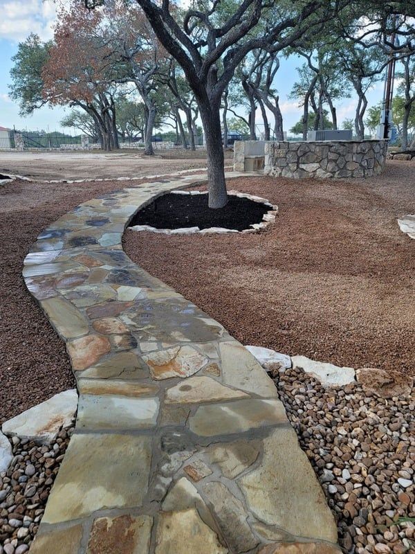 Stone walkway curves through a landscaped park