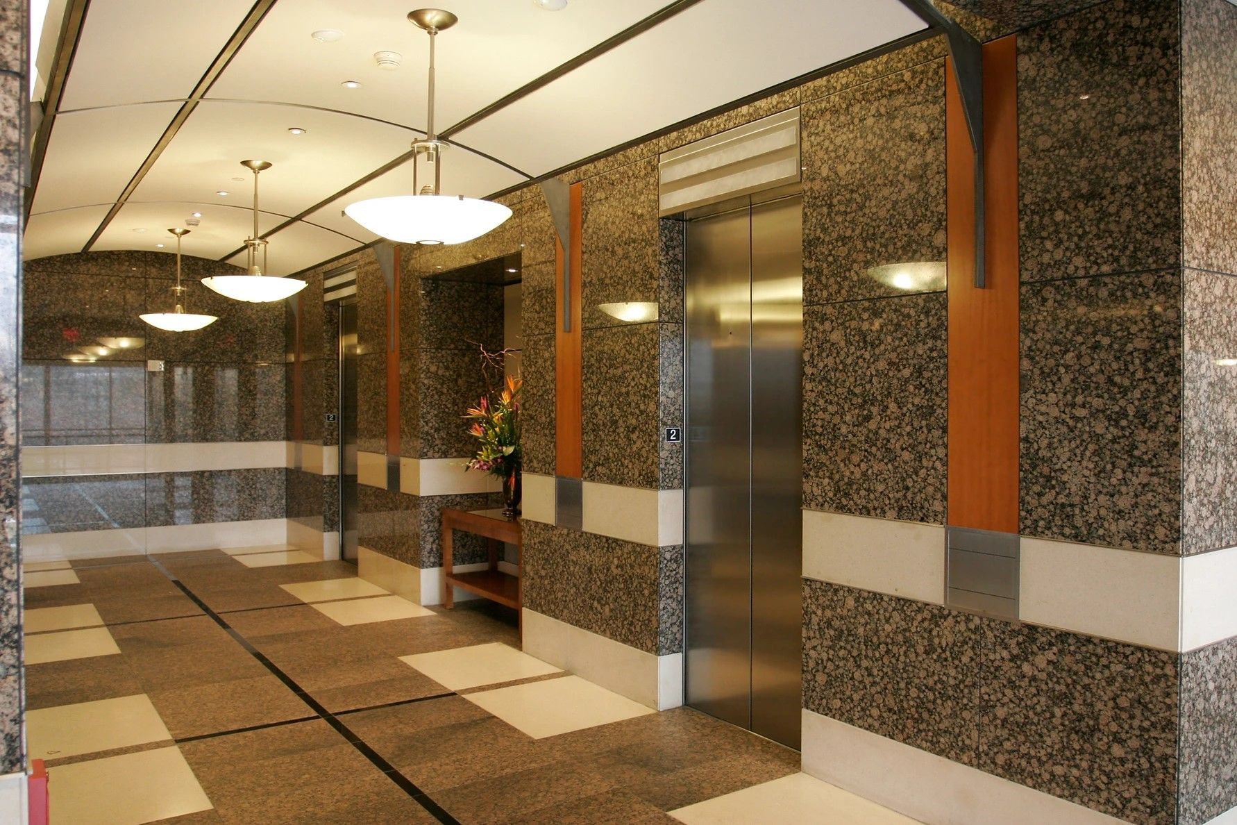An elevator in a building with granite walls