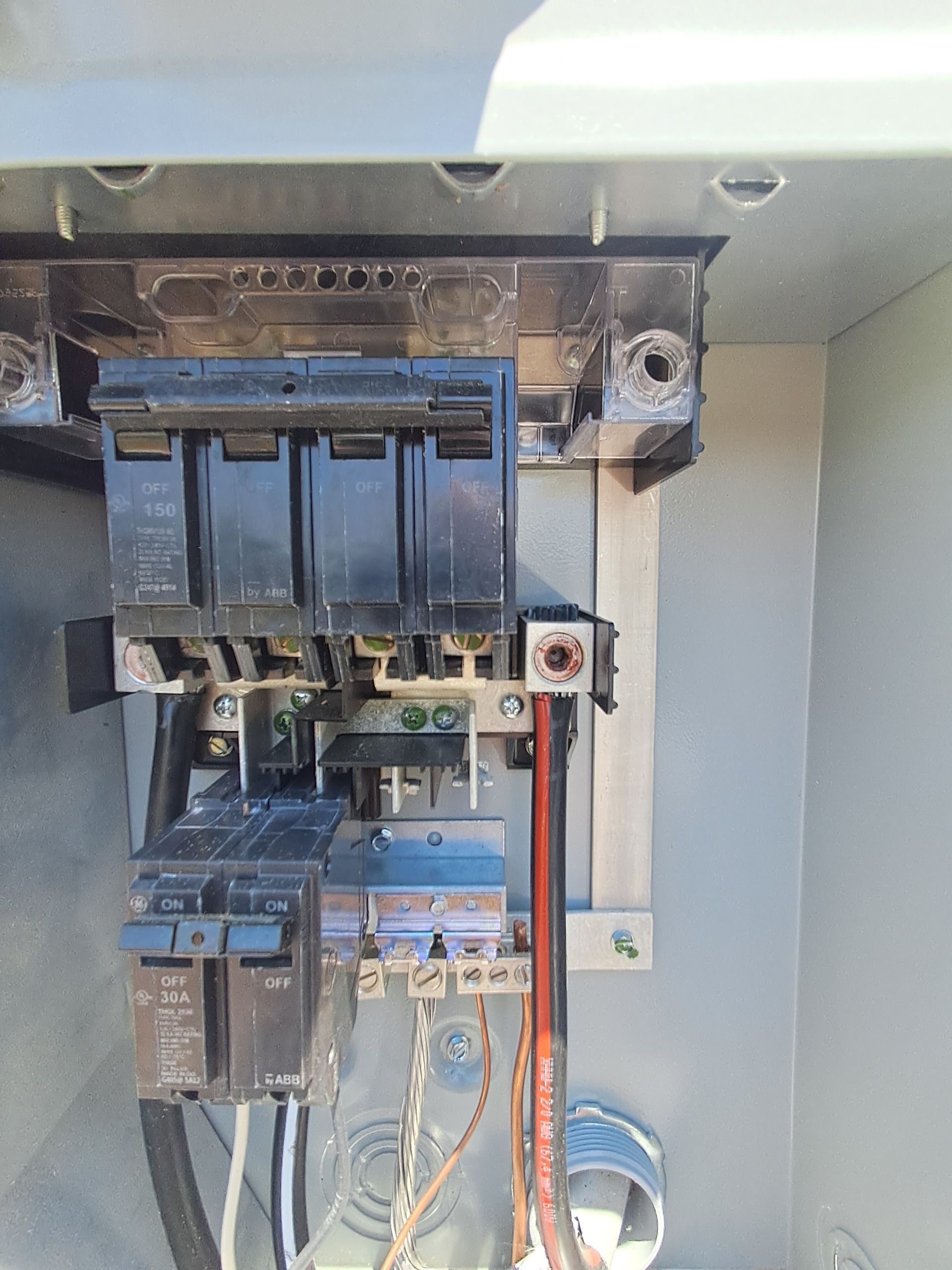 Electrical panel with circuit breakers and wiring.