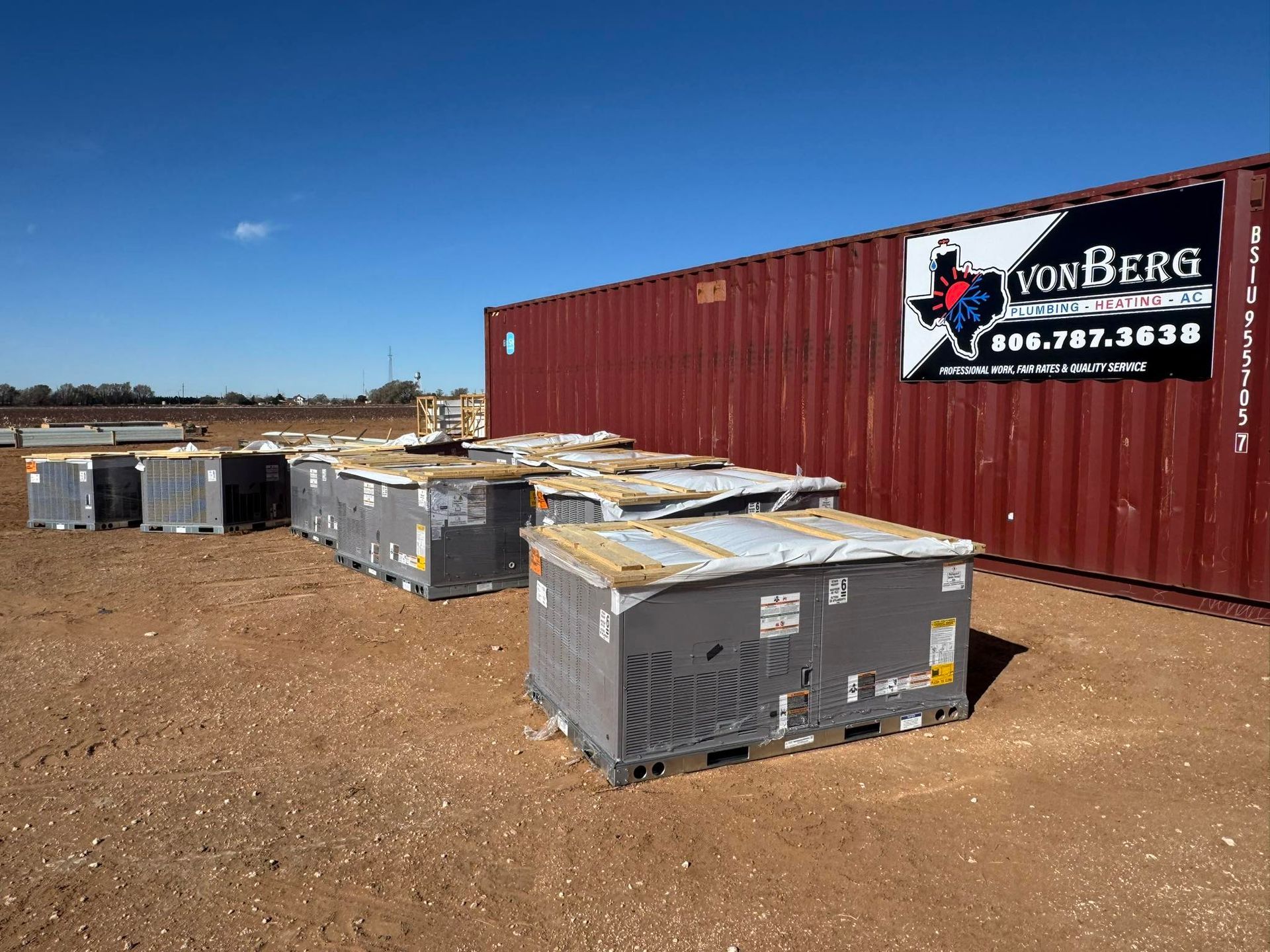 Boxes on pallets outside a red shipping container, under a blue sky. VonBerg logo visible.
