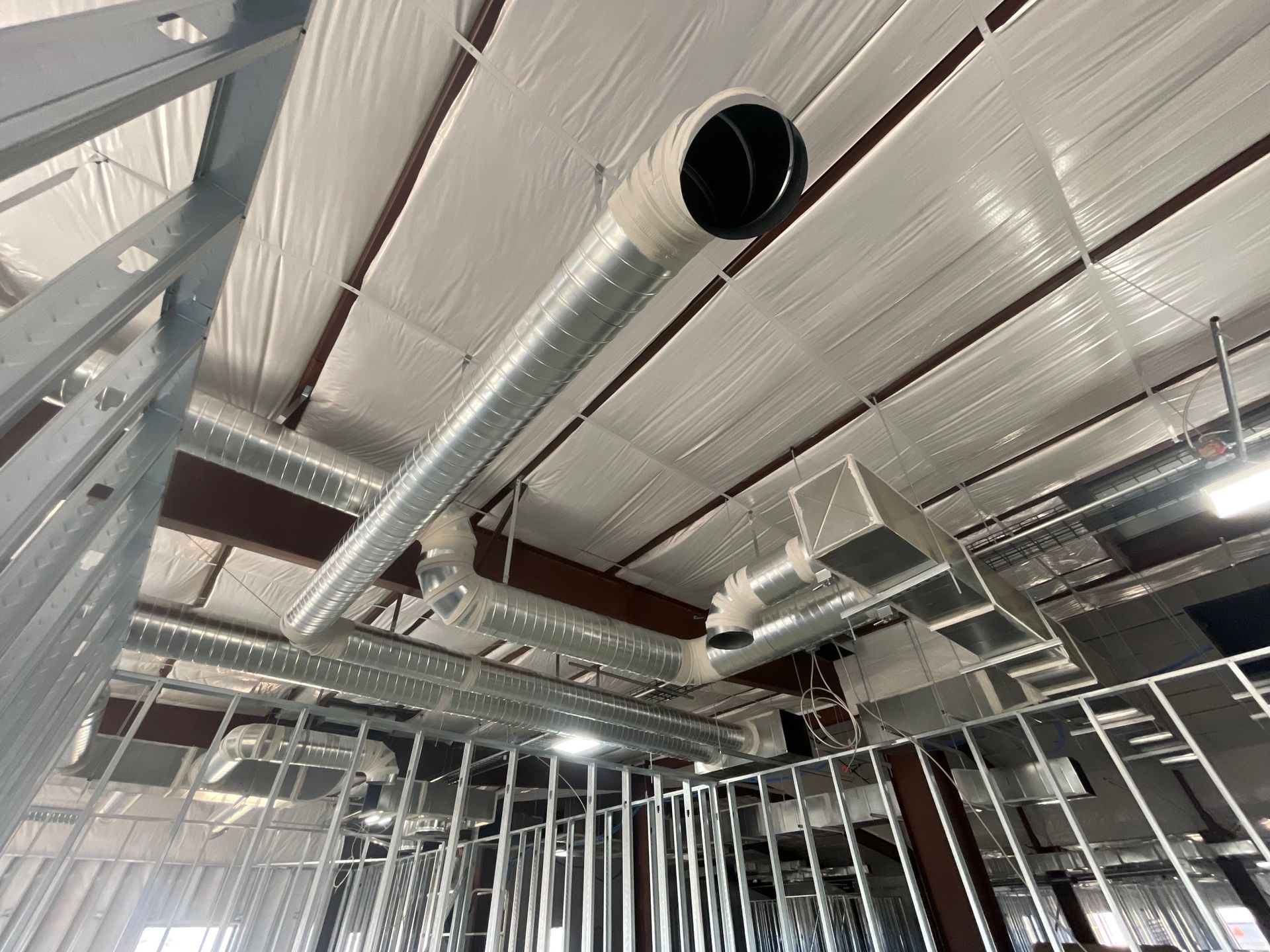 Exposed metal ceiling with ducts and insulation in a building under construction