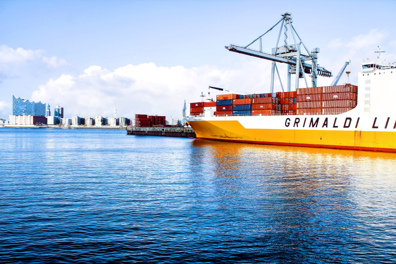 A large container ship is docked in a harbor.