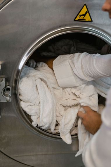 Laundry being loaded into a front-loading industrial washer