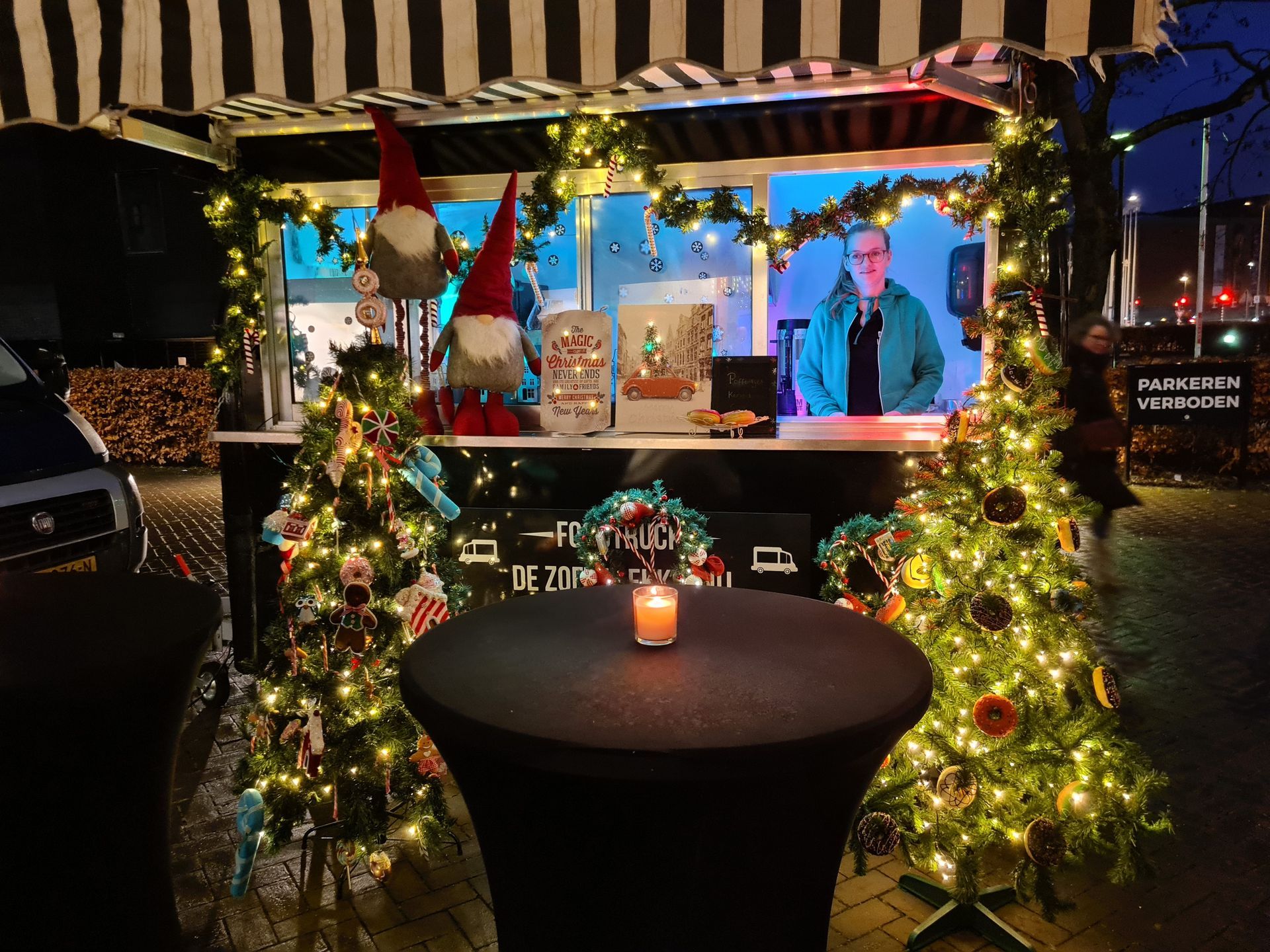 Een kerstboom staat voor een foodtruck