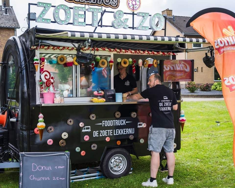 Een man die voor een foodtruck staat met de tekst zoet & zo